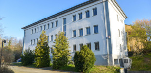 Die Niederlassung des Versorgungsverbands Grimma-Geithain. Ein weißes Gebäude mit vielen Fenstern.