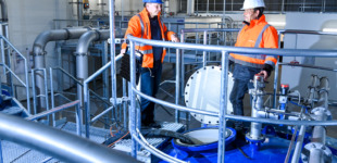 Zwei Mitarbeiter in orangener Jacke im Wasserrwerke in Prießnitz.